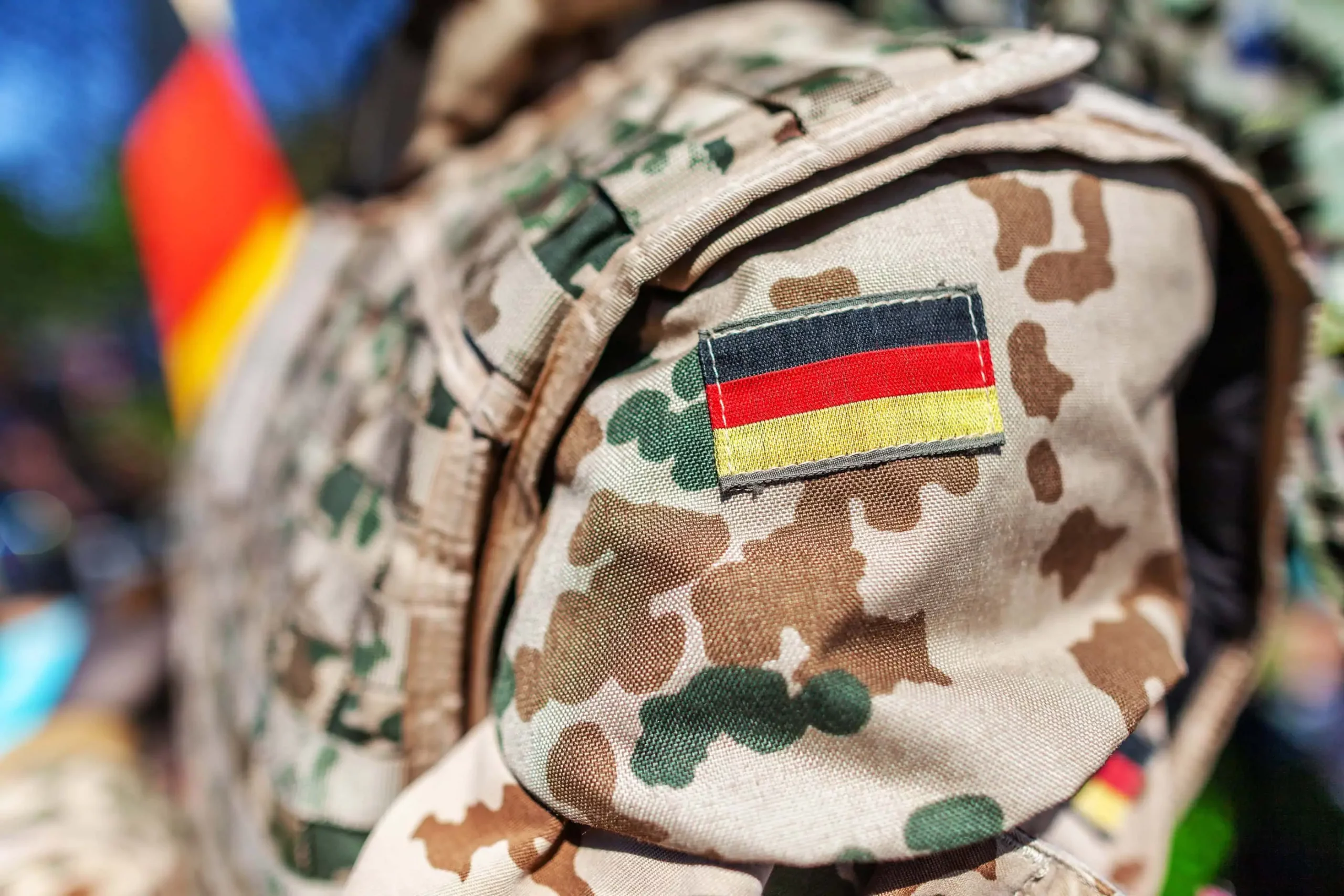 Flecktarn-Uniform mit Deutschlandflagge am Ärmel – Kontakt zum paladinum Soldatenservice